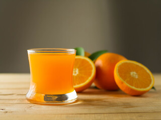 Fresh orange juice in a clear glass on a wooden background, fruits that contain vitamins.