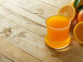 Fresh orange juice in a clear glass on a wooden background, fruits that contain vitamins.