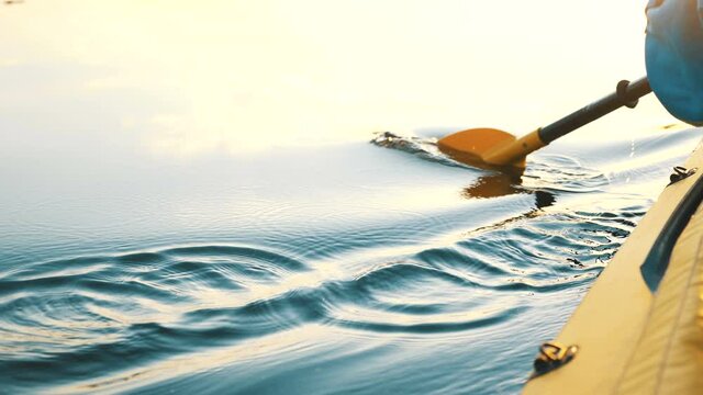 oar paddles on calm water against the background of sunset rays, outdoor activities on a kayak, water sports