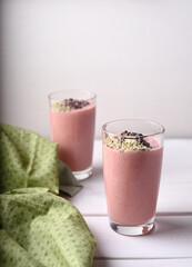 Two strawberry raspberry smoothies with green napkin