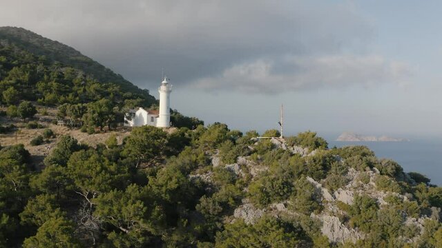 A young man waving in the background of lighthouse. Natural landscape. Gelidonya, Adrasan