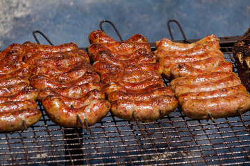 Hundreds of sausages on a grill roasting