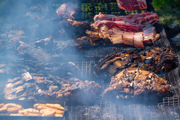Different types and cuts of meat on a large country grill