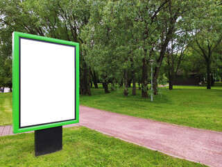 A green information stand with place for text stands in a summer park on a green lawn