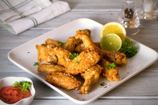 Deep fried chicken wings on white plate. Horizontal image