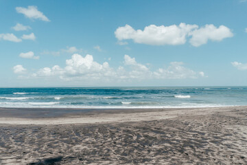 Fototapeta na wymiar large waves crashing in sand beach rocks on bali island