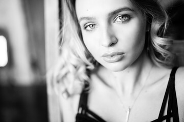 Close up monochrome portrait of curly blond charming woman.