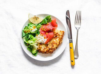 Spanish potato tortilla with greek yogurt, smoked salmon and green salad on a light background, top view