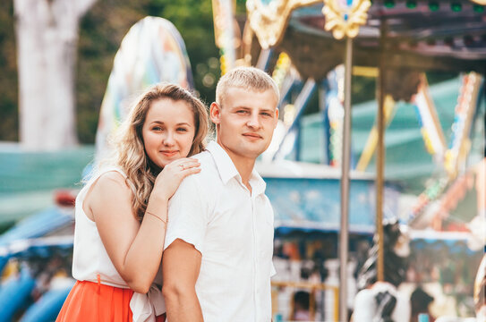 Portrait of two young people walking at the city park posing at the camera. Sensual feelings of in love couples concept image.