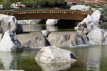 Fototapeta na wymiar wooden bridge in formal garden over a pond