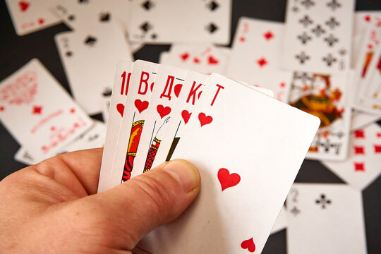 Playing cards in hands on a background of scattered cards.