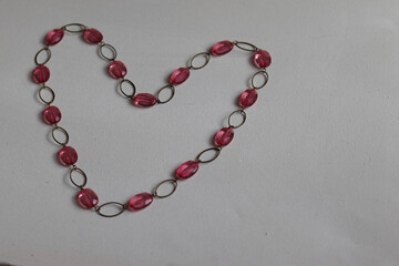 pink heart shaped necklace on white background