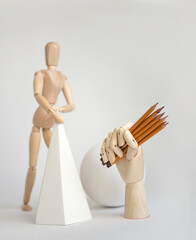Wooden hand with pencils in hand.  Art supplies. Art. School. Education. Pencil. The wooden man. Drawing. Trainings.  Stationery. 