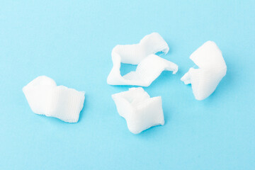White gauze pads on  blue background. Materials for dental surgery. Close up