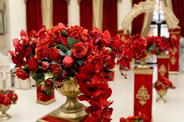 red flowers in a pot on a pedestal