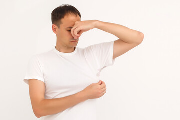 man shows a stain on his white t-shirt