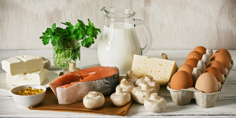 Vitamin D rich foods on a white wooden table, banner. Natural sources of vitamin D are dairy...