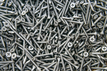 Background of metal nails top view close-up. Background from a variety of building steel sharp nails macro. A big pile of nails. Гвозди. Шурупы. 