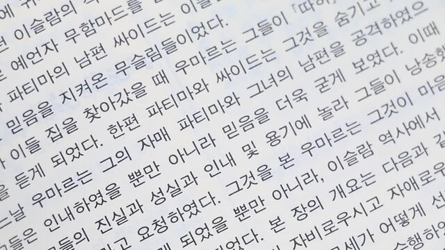 Slow panning shot of Korean text in book