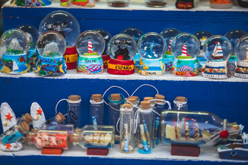 View of traditional tourist souvenirs and gifts from Calpe, Calp, Alicante, Valencia with toys, fridge magnets with and key ring keychain, in local vendor souvenir shop