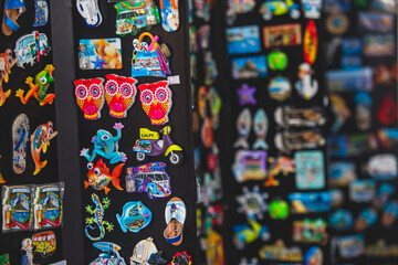 View of traditional tourist souvenirs and gifts from Calpe, Calp, Alicante, Valencia with toys, fridge magnets with and key ring keychain, in local vendor souvenir shop