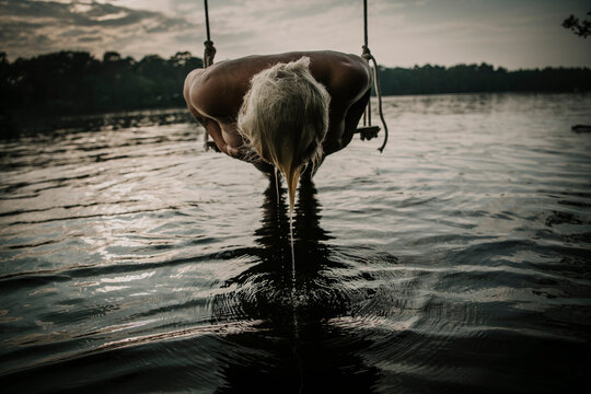 Woman lying on swing over lake