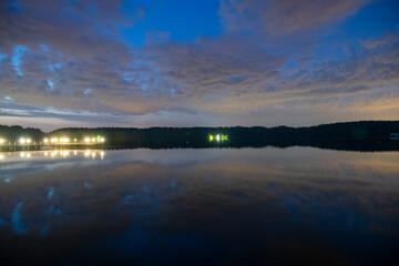 landscape with bright clouds and with reflections in the river before dawn