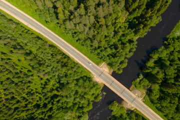 Aerial high angle view of highway and bridge over river in deep forest, Moscow area, Russia