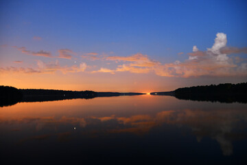 landscape with bright clouds and with reflections in the river before dawn