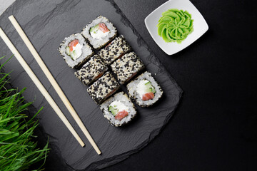 Sushi VENICE rolls with sesame and salmon with wasabi  on a Board made of stone. Sushi food photo for menu.The view from the top