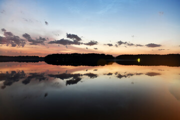 landscape with bright clouds and with reflections in the river before dawn