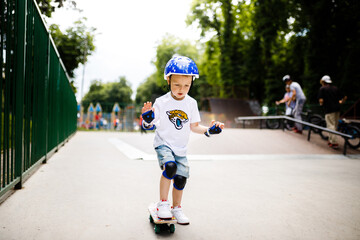 Boy with a skate in a skate park. The boy learns to skate, in full protection.