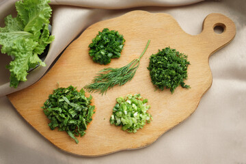Green ingredients prepared for cooking on a wooden chopping board, flatlay