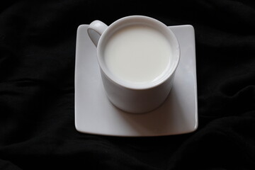 Home cozy composition. Cup of milk on black background. Fall background. Flat lay, top view, copy space
