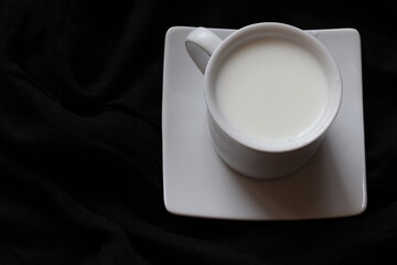 Home cozy composition. Cup of milk on black background. Fall background. Flat lay, top view, copy space