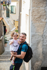 
father and daughter having fun on the streets of an old village called FiumeFreddo, Calabria, Italy