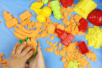 Obraz premium Kinetic sand. Child building sandcastle various figures