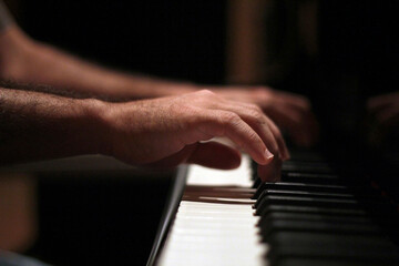 Fototapeta na wymiar Hands playing piano in close up