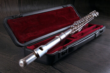 Transverse flute on case with red velvet on wooden background