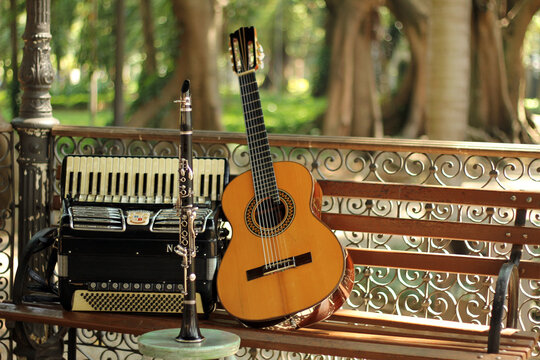 Musical instruments, accordion, clarinet, 7-string guitar, on wooden bench in a bandstand in the square