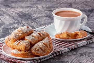 Freshly baked homemade puffs with aromatic coffee on a gray background