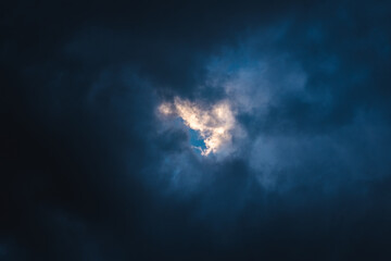 Sky glimpsed by gray clouds to form a heart