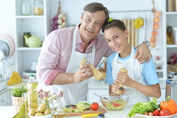 Portrait of father and son cooking breakfast in the kitchen