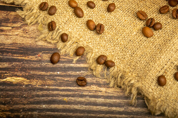 Coffee beans on a background of homespun fabric with a rough texture. Close up.