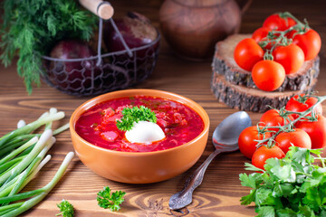Borscht. Red soup in bowl with sour cream on wooden background. National ukrainian or russian red soup