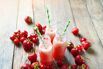 Glass bottles with a red smoothies made with red  berries and fruits. Summer beverage background.