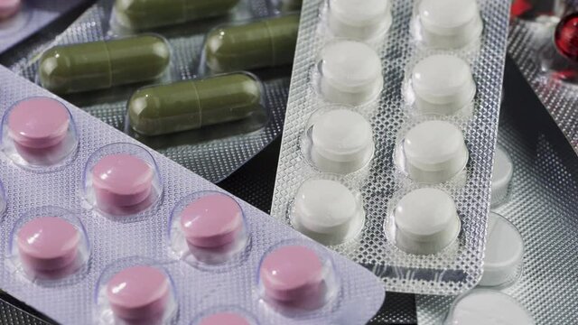 Close-up view of packages with medical pills rotating. Medicine, pills and tablets with blister packs turning. Pharmaceutical Industry. The medicine concept.