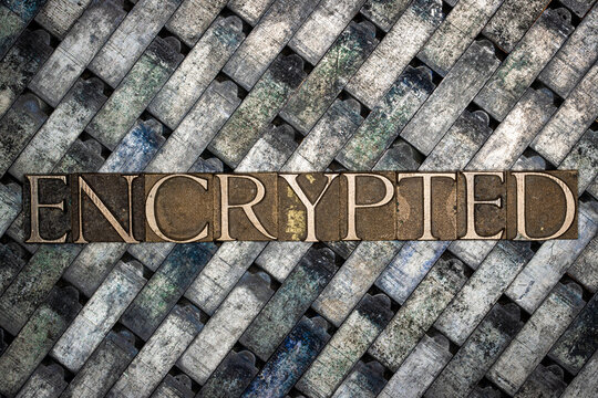 Encrypted text formed with real authentic typeset letters on vintage textured silver grunge copper and gold background