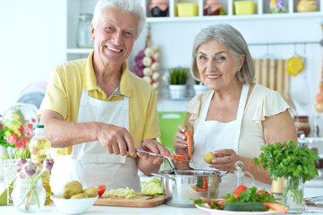 Obraz na płótnie Canvas Portrait of senior couple cooking together at kitchen