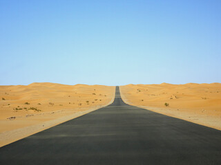 Road crossing an endless expanse of sand